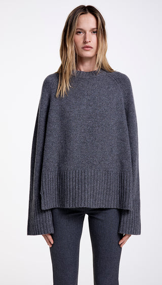 A woman wearing a gray oversized cashmere sweater with a step hem and double rib collar.