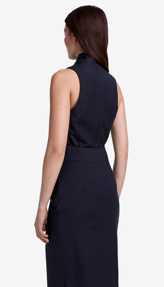 Woman wearing a sleeveless navy dress on a white background