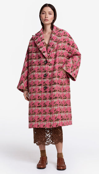 Woman wearing a pink plaid coat on a white background