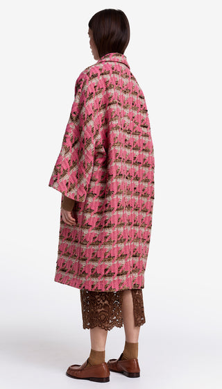 Person wearing a pink and black patterned coat on a white background