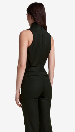 Woman wearing a black sleeveless top and high-waisted pants on a white background