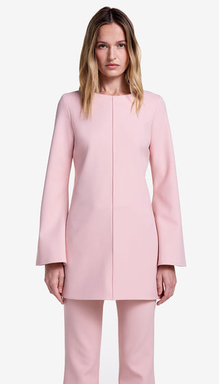 Woman wearing a pink coat and pants on a white background