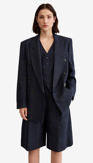 Woman wearing a navy blue suit with a coat and shorts on a white background