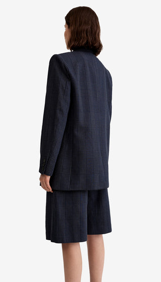 Person wearing a navy checkered suit on a white background