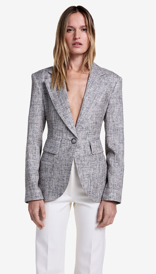 Woman wearing a gray blazer over a white top on a white background