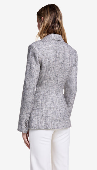 Person wearing a gray checkered blazer and white pants on a white background