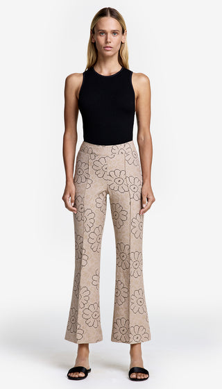 A model wearing a black tank top and cropped pintuck pants with a floral pattern.