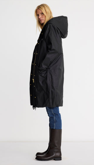 Woman wearing a black raincoat on a white background