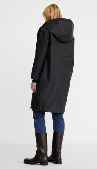 Person wearing a black raincoat on a white background