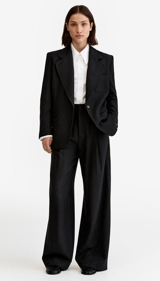 Person wearing a black suit with a white shirt on a white background