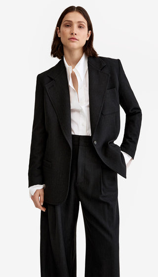 Person wearing a black suit with a white shirt on a white background