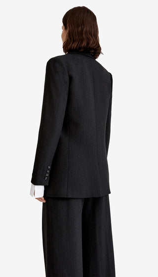 Person wearing a black suit on a white background