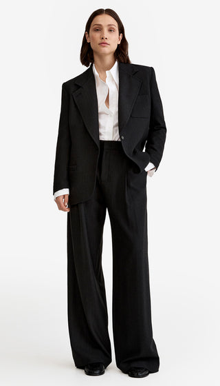 Person wearing a black suit with a white shirt on a white background