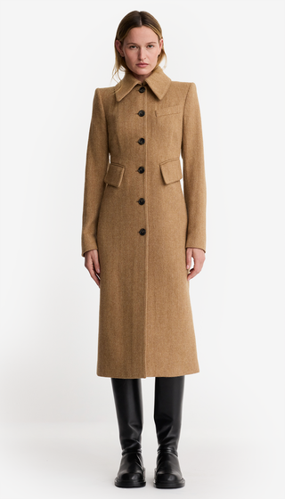 Woman wearing a long brown coat on a white background