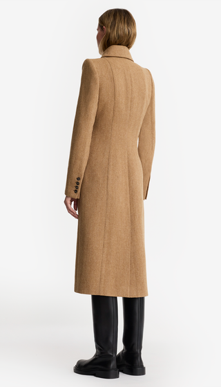 Person wearing a long beige coat on a white background