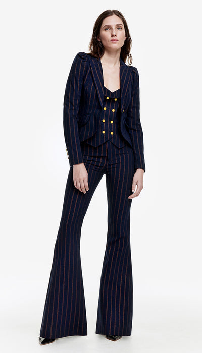A model wearing a navy copper pinstripe pouf sleeve one button blazer with a coordinating waistcoat and pant.