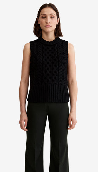 Woman wearing a black sleeveless knitted top on a white background