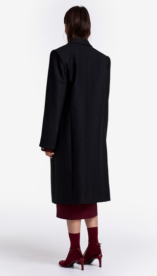 Person wearing a black coat on a white background