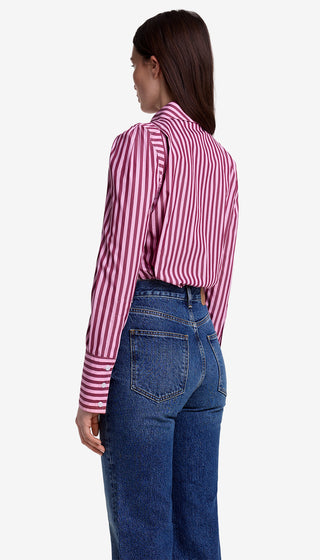 Person wearing a pink and white striped shirt and blue jeans on a white background