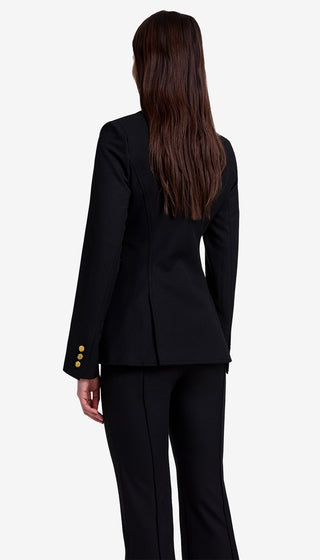 Person wearing a black suit with gold buttons on a white background
