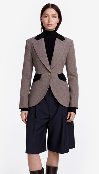 Woman wearing a gray blazer with black trim and a black top on a white background