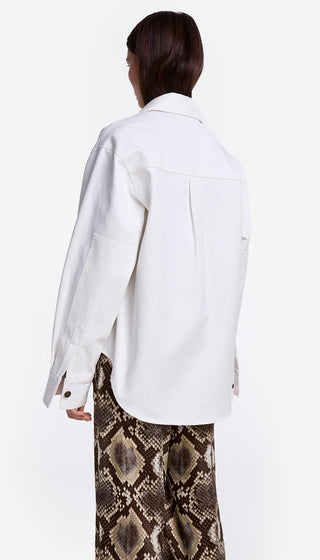 Person wearing a white jacket and snake print pants on a white background