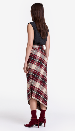 Woman wearing a plaid skirt and dark top on a white background