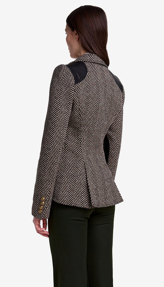 Woman wearing a patterned blazer from behind on a white background