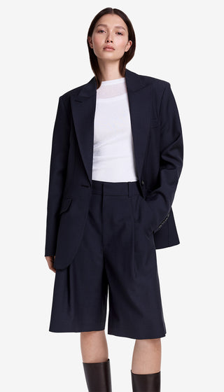 Person wearing a navy blazer and black wide-leg pants on a white background