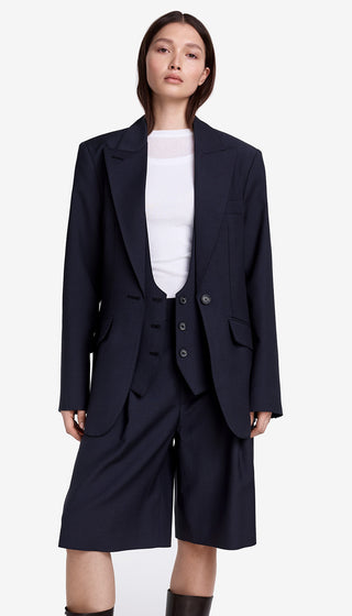 Person wearing a navy blue suit with a white shirt on a white background