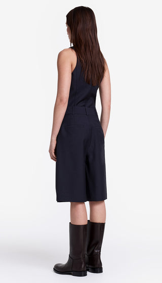 Woman wearing a navy blue sleeveless dress with a white background