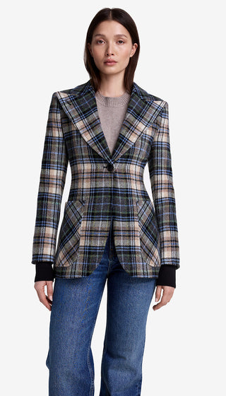 Woman wearing a plaid blazer and jeans on a white background