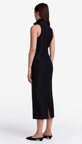 Woman wearing a black sleeveless dress with a slit on a white background