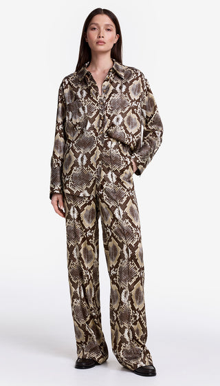Person wearing a snake print outfit on a white background