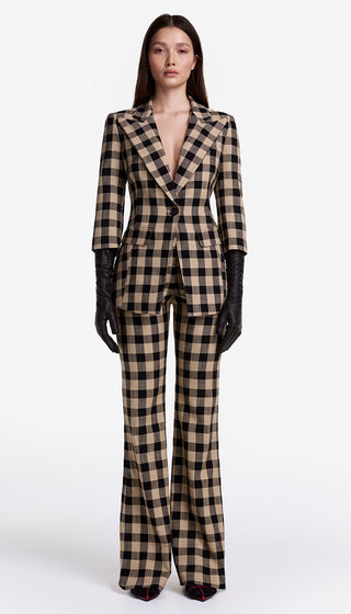 Model wearing a checkered suit with gloves on a white background