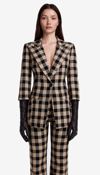 Woman wearing a checkered suit with black gloves on a white background