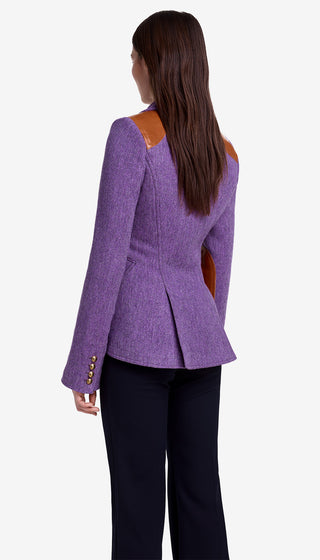 Person wearing a purple blazer with orange accents on a white background
