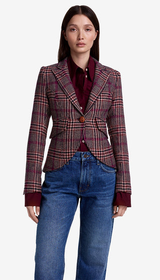Woman wearing a plaid blazer and blue jeans on a white background