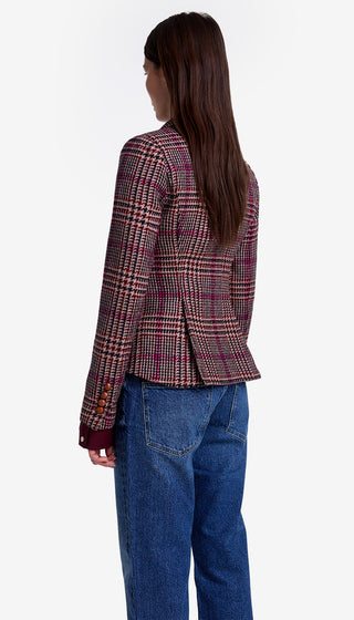 Person wearing a plaid blazer and blue jeans on a white background