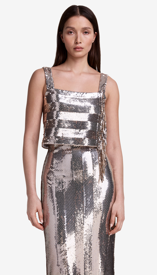 Woman wearing a silver sequin dress on a white background