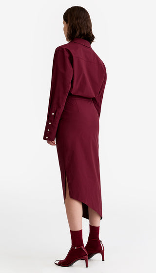 Woman wearing a burgundy dress with a white background