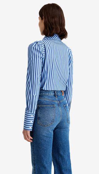 Person wearing a blue and white striped shirt and blue jeans on a white background