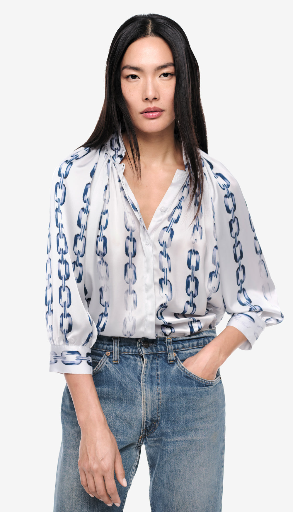 A woman in a white and blue printed blouse.