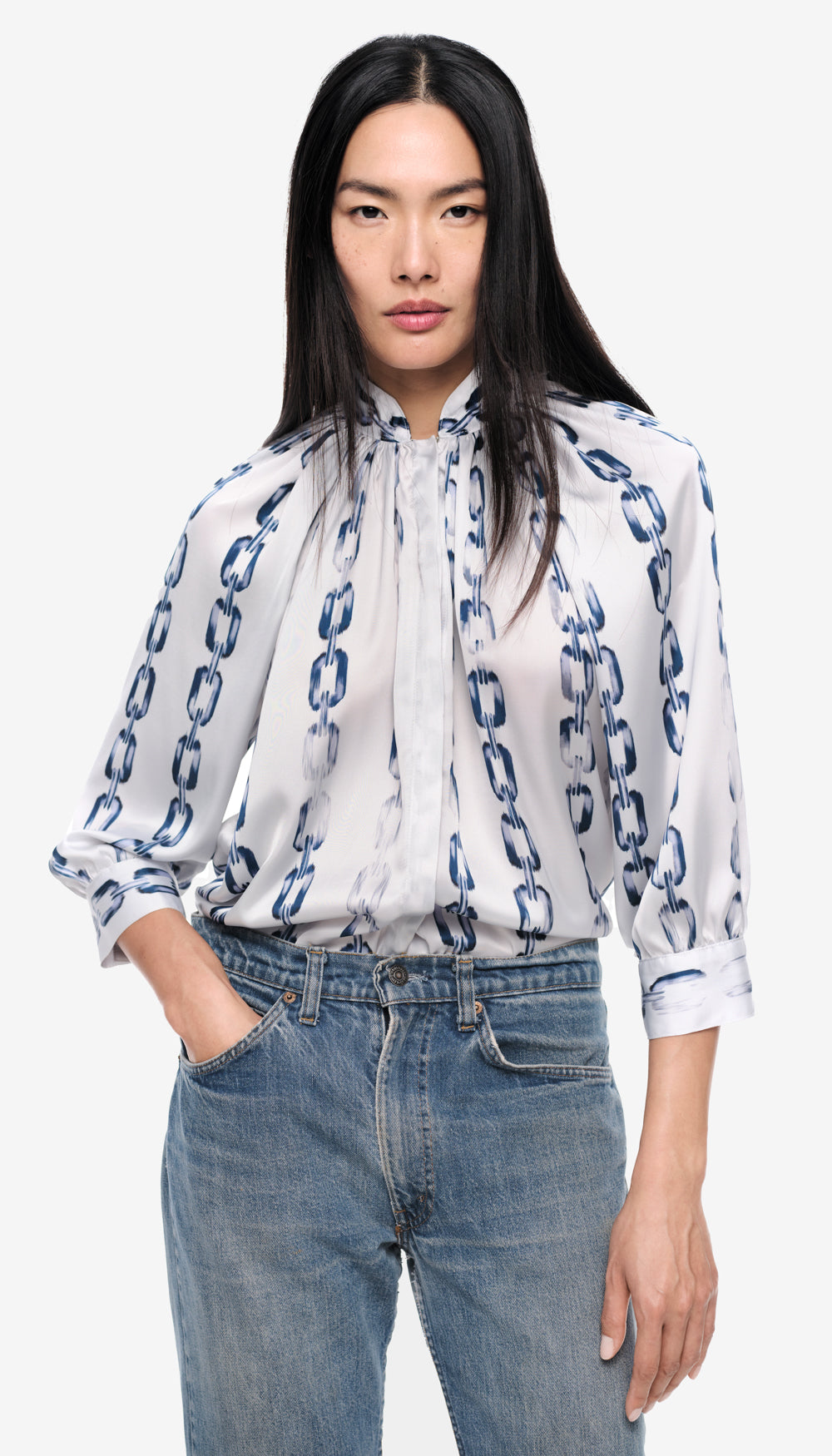 A woman in a white and blue printed blouse.