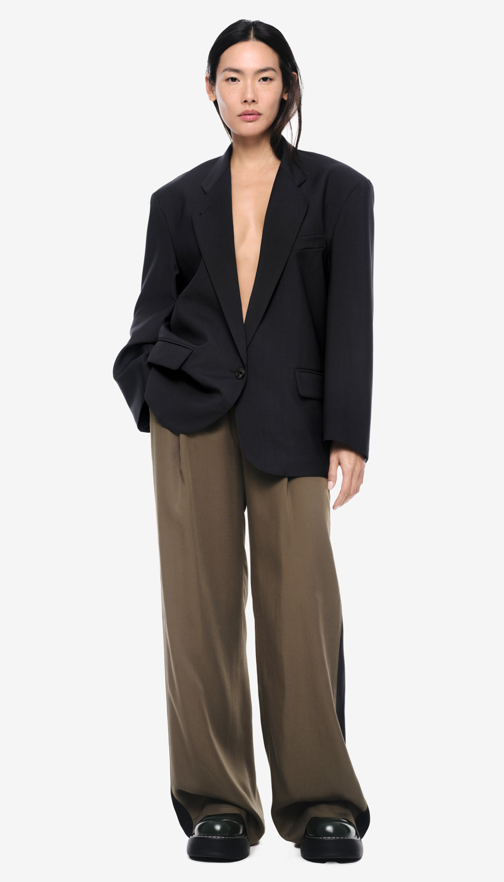 A woman in an oversized solid carbon blazer.