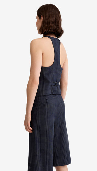 Woman wearing a navy checkered jumpsuit on a white background