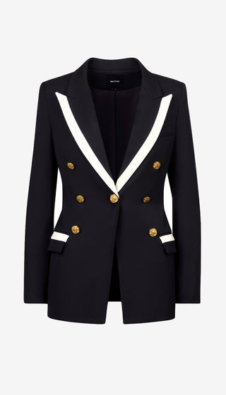 Black blazer with white lapels and gold buttons on a light gray background