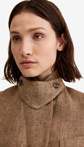 Close-up of a person wearing a brown coat with a high collar.