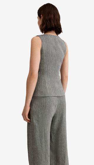 Person wearing a gray sleeveless top and wide-leg pants on a white background