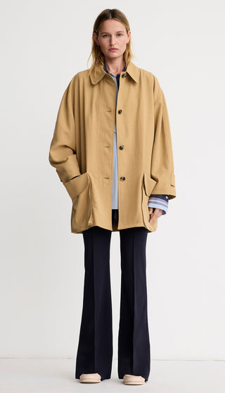 Woman wearing a beige coat on a white background